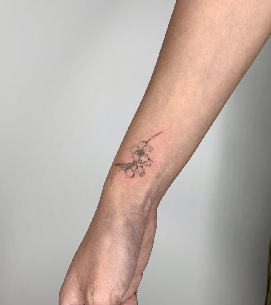 Small jasmine flowers tattoo on outer wrist delicate floral ink