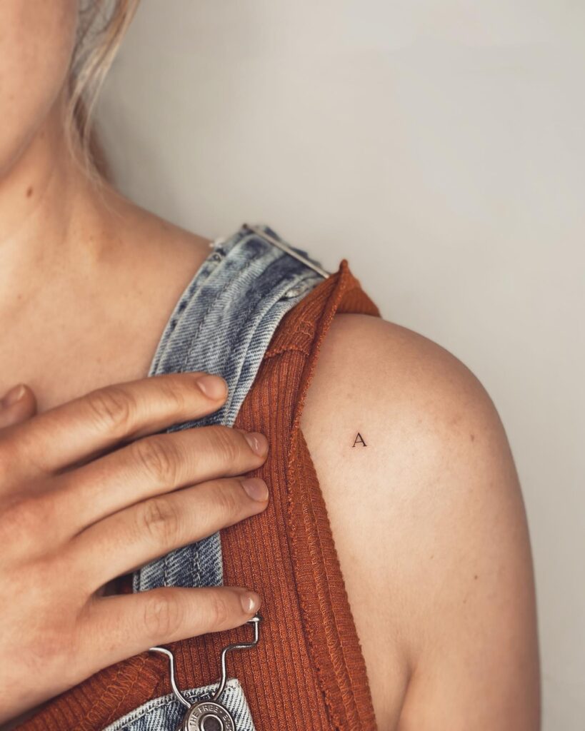 Small Letter 'A' Tattoo Adorning the Arm and Shoulder: Shoulder Statement