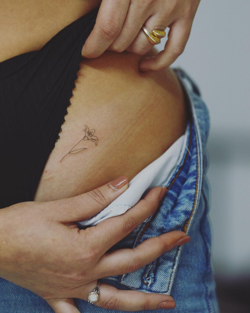 Small Lily Tattoo on the Hip, Delicate Petals Gracefully Adorning the Canvas: Lily Elegance