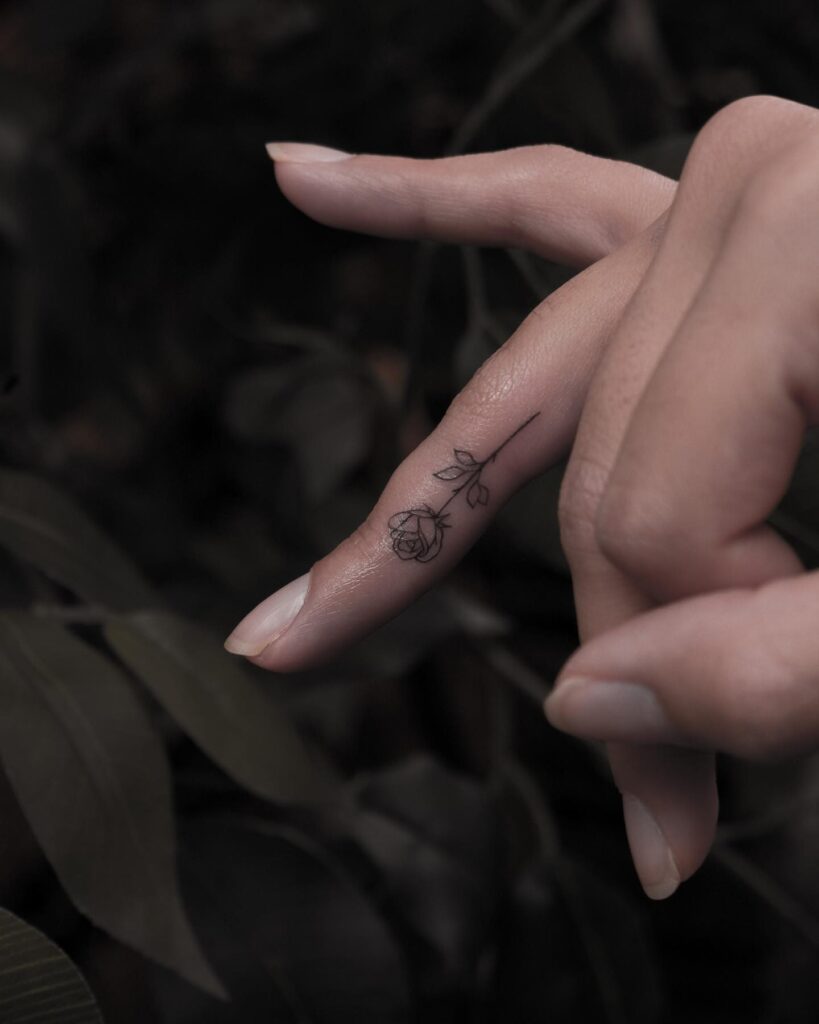 Small rose flower tattoo on the side of the ring finger rose ring