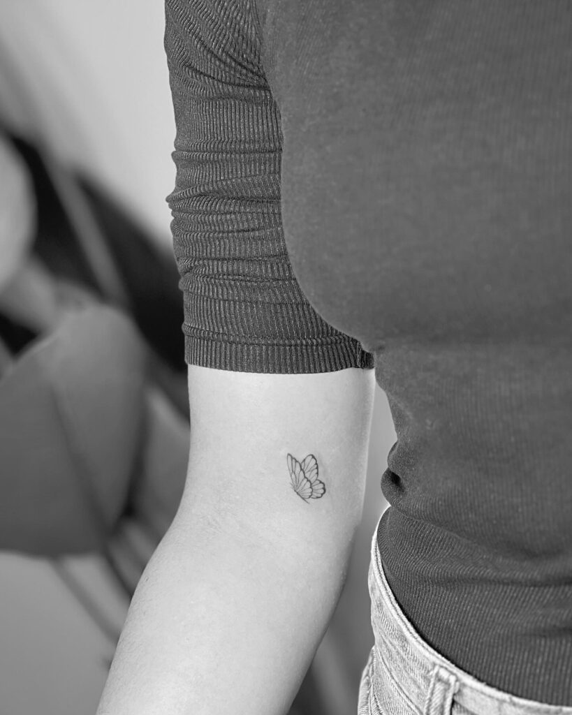 Small Side View Butterfly Tattoo Above the Elbow, Capturing Ephemeral Beauty: Aerial Grace