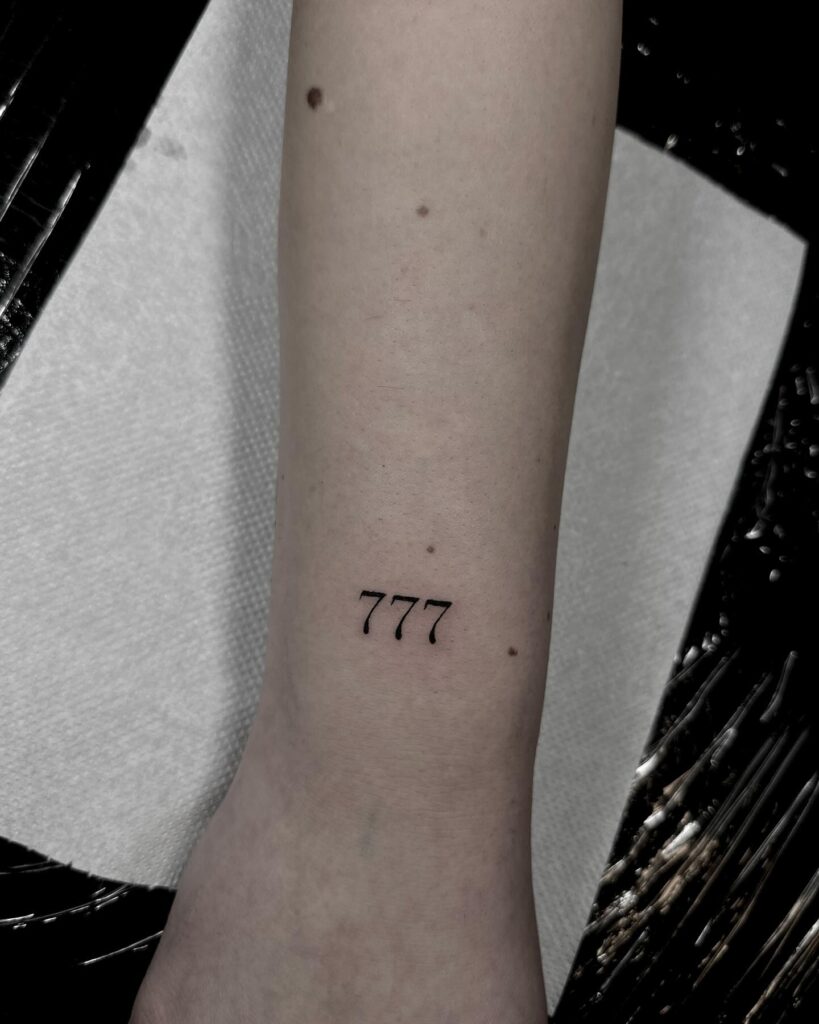Small tattoo 777 on the outer wrist, blending minimalism with numerical elegance wrist whispers 