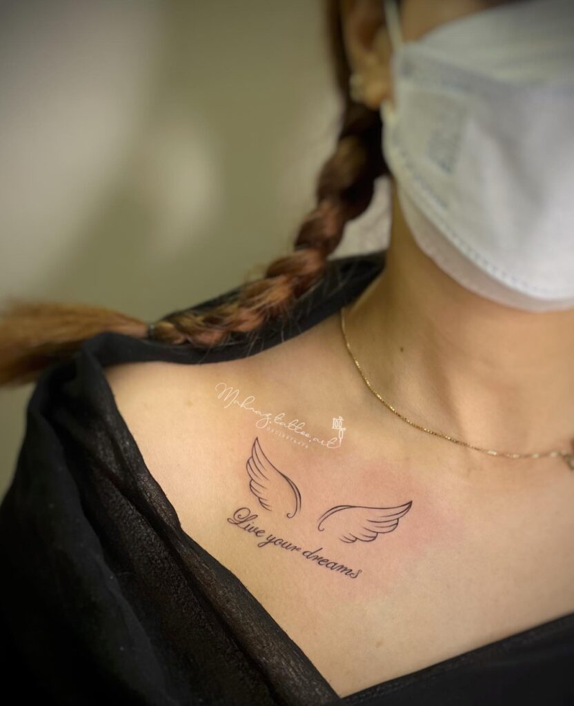 Small Wings Tattoo with 'Live Your Dreams' in Cursive Lettering: Collarbone Whispers