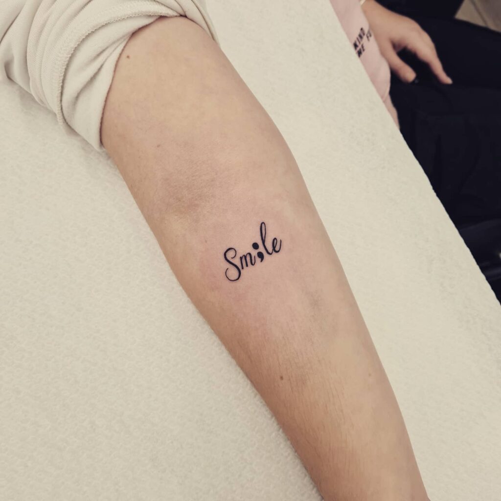 Sm;le Text Lettering Tattoo on the Forearm: Smile with Purpose
