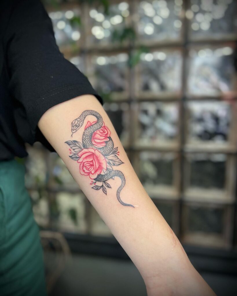 Snake Wrapped with Two Red Roses Tattoo Making a Statement on the Forearm: Serpentine Beauty