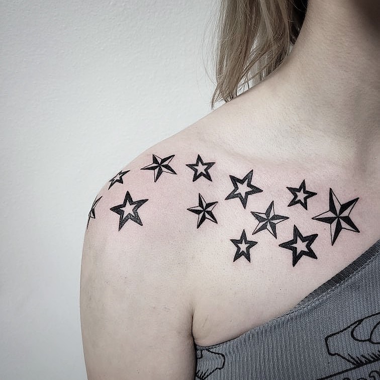 Starry grouping female shoulder tattoo with a cluster of stars