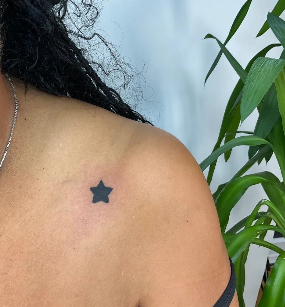 Starry simplicity single filled-in star tattoo on the female shoulder