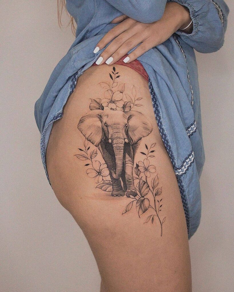 Stunning big elephant with flowers side hip and thigh tattoo in black and grey for females, front view on a larger canvas majestic bouquet