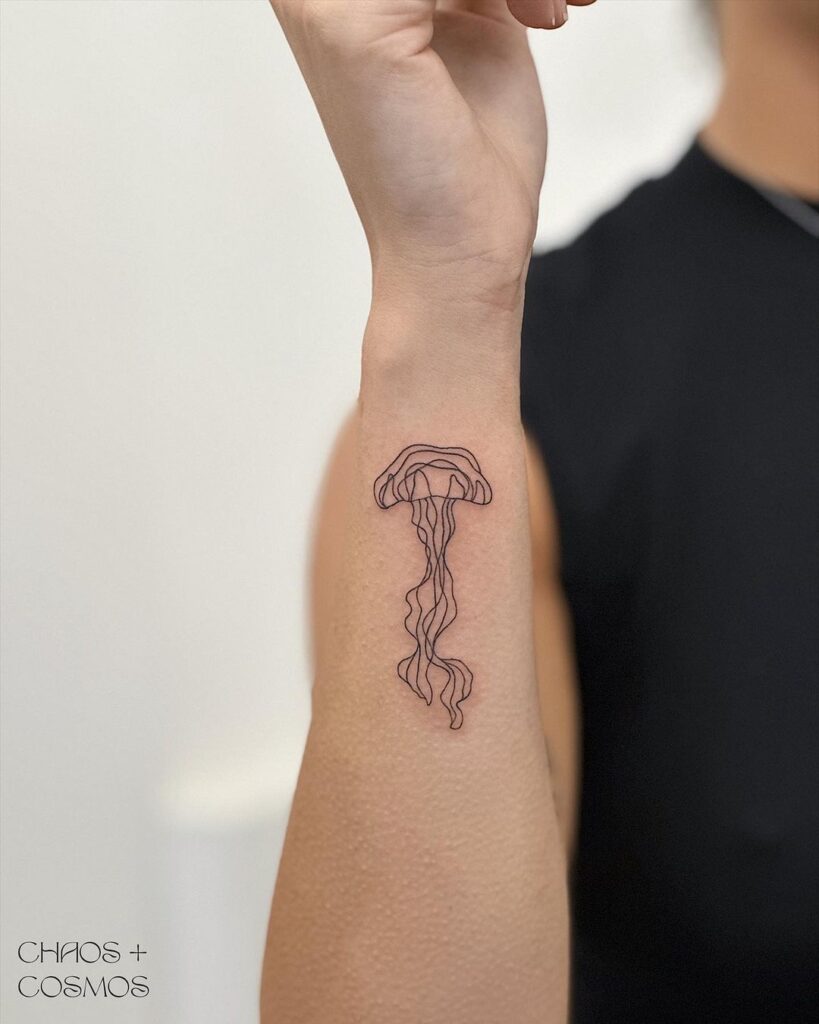 Stunning lined jellyfish tattoo on the side wrist marine beauty