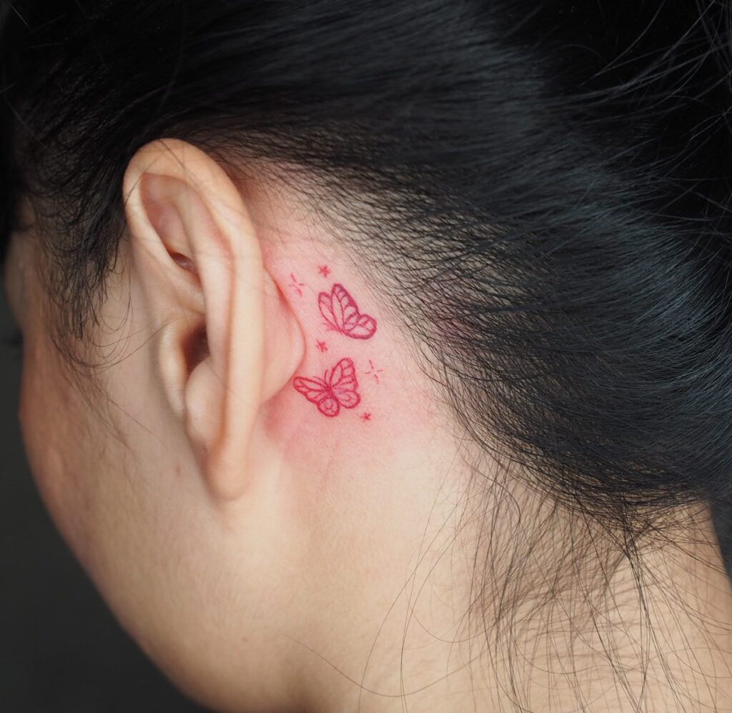 Stunning pair of red outlines dual butterfly tattoo elegance behind the ear for females