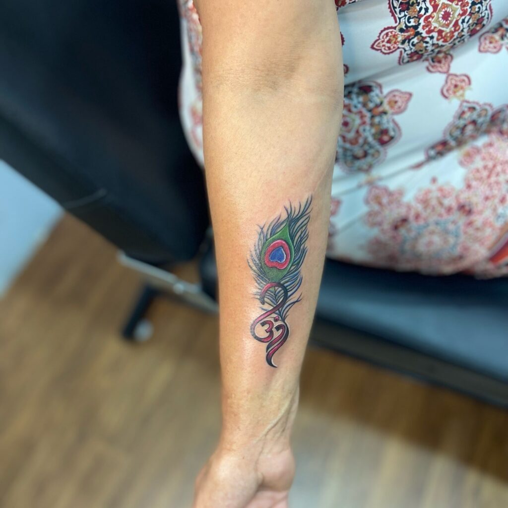 Stylish Peacock Feather Tattoo with Om Symbol Spiritual Beauty