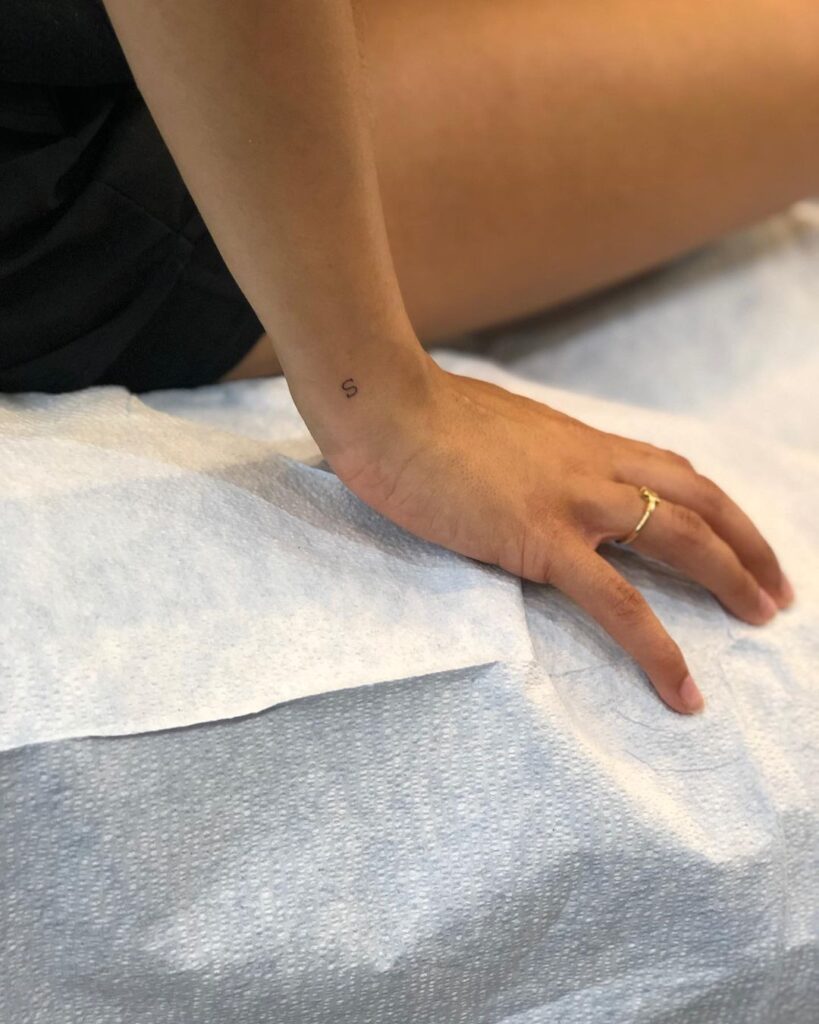 Stylish s lettering tiny fineline tattoo on the side wrist