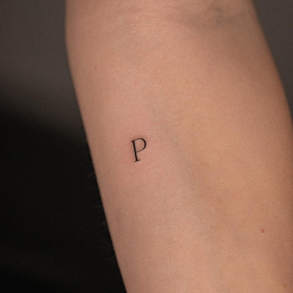 Subtle 'P' Letter Tattoo on the Side: Forearm Minimalism
