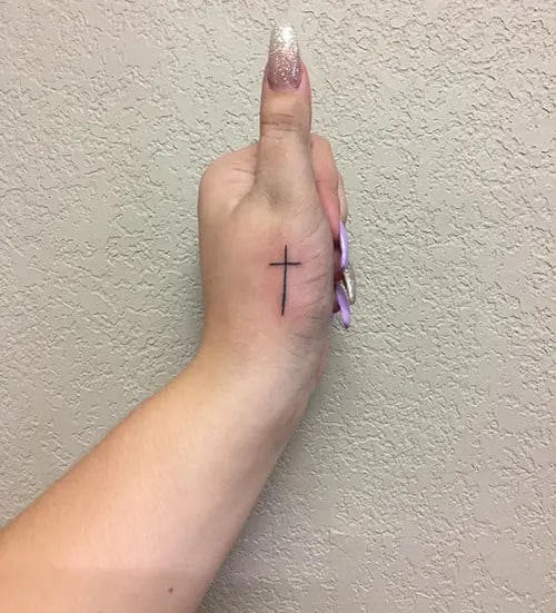 Subtle Symbolism Cross Tattoo on the Thumb