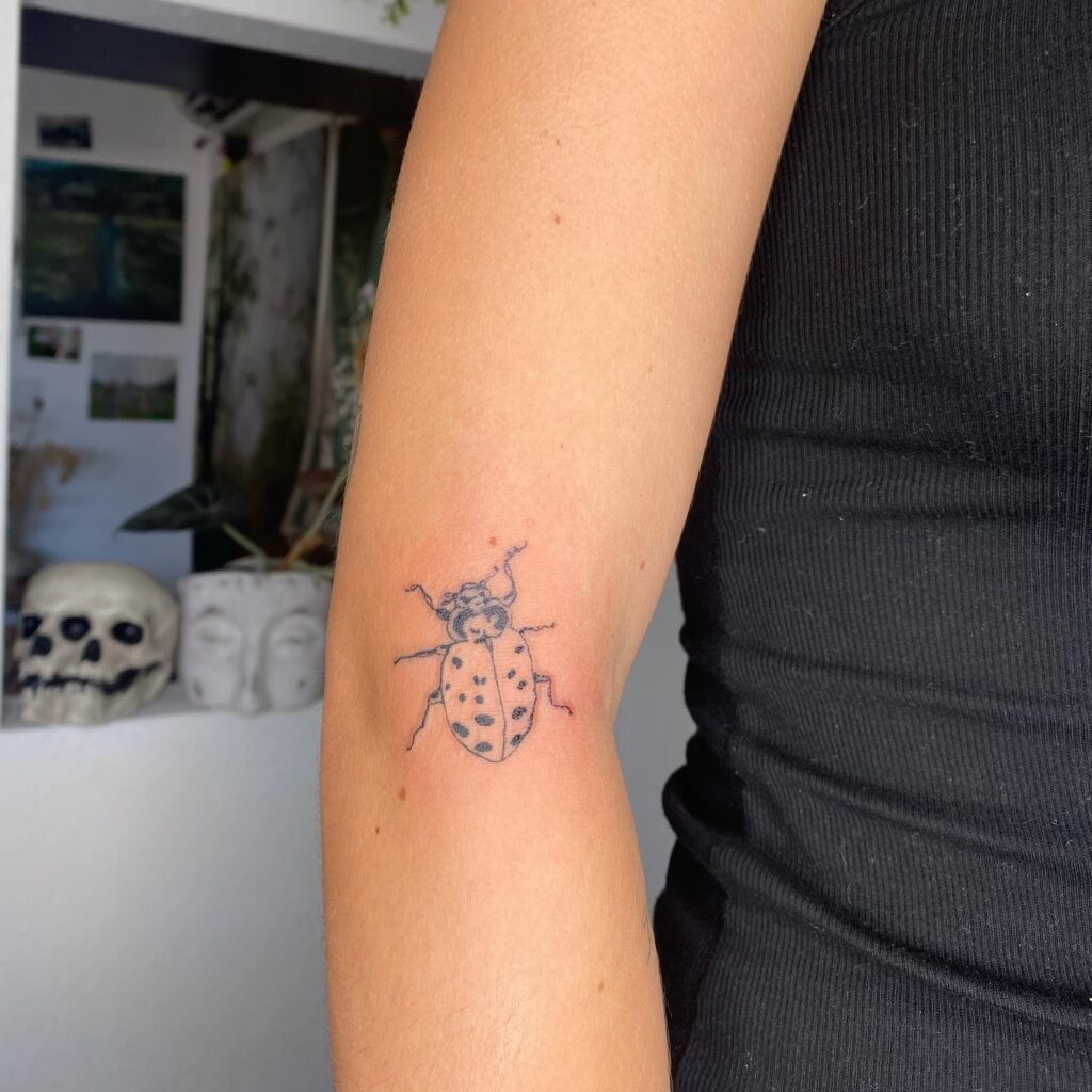 Subtle and stylish small ladybug tattoo on the elbow