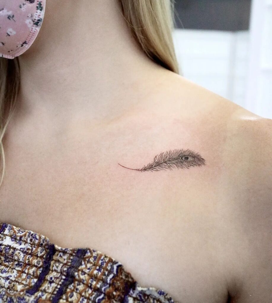 Subtle collarbone charm delicate peacock feather tattoo for women