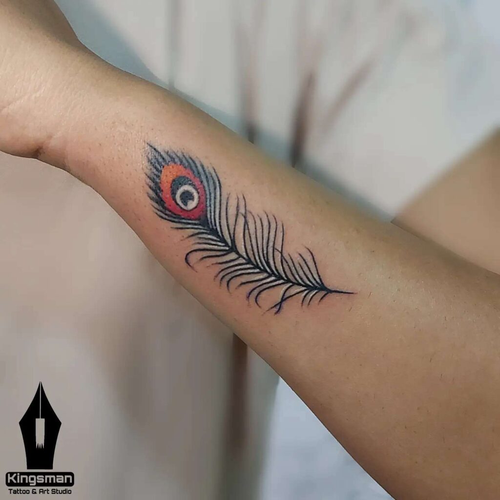 Subtle feather adornment outer wrist peacock feather tattoo