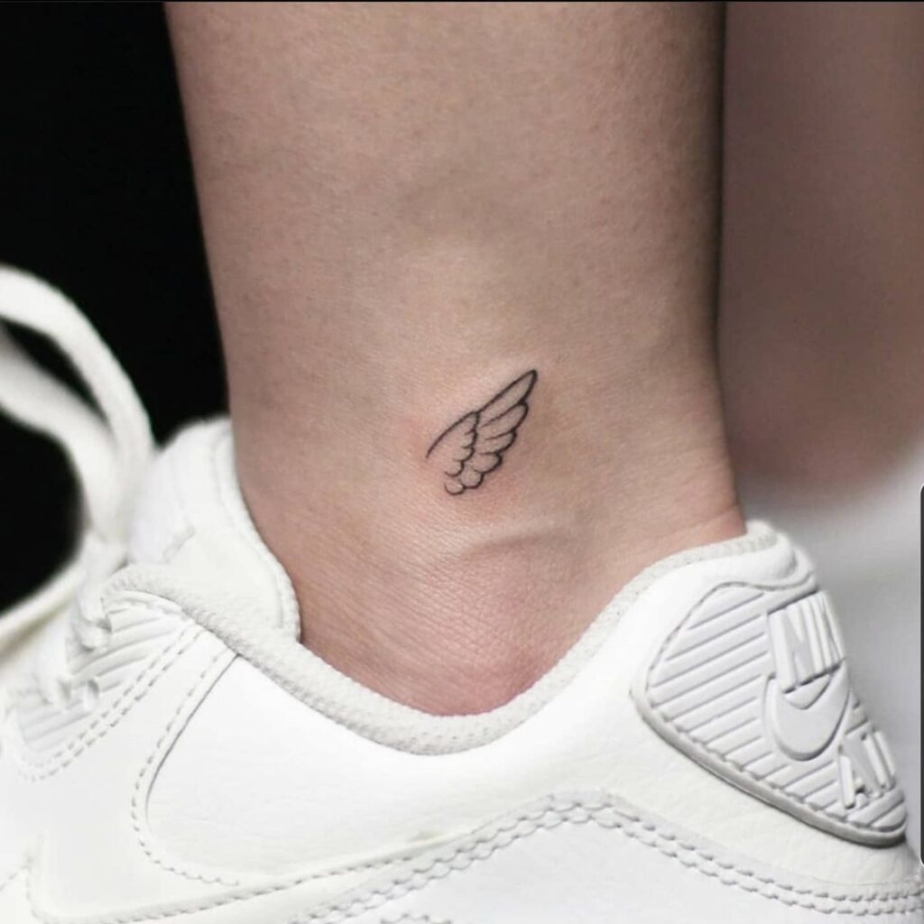 Subtle statement small wings tattoo on the ankle
