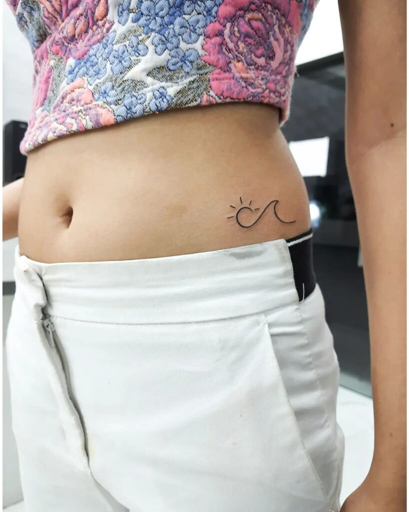 Subtle Stomach Tattoos: Small Sun and Wave Artistry for Women