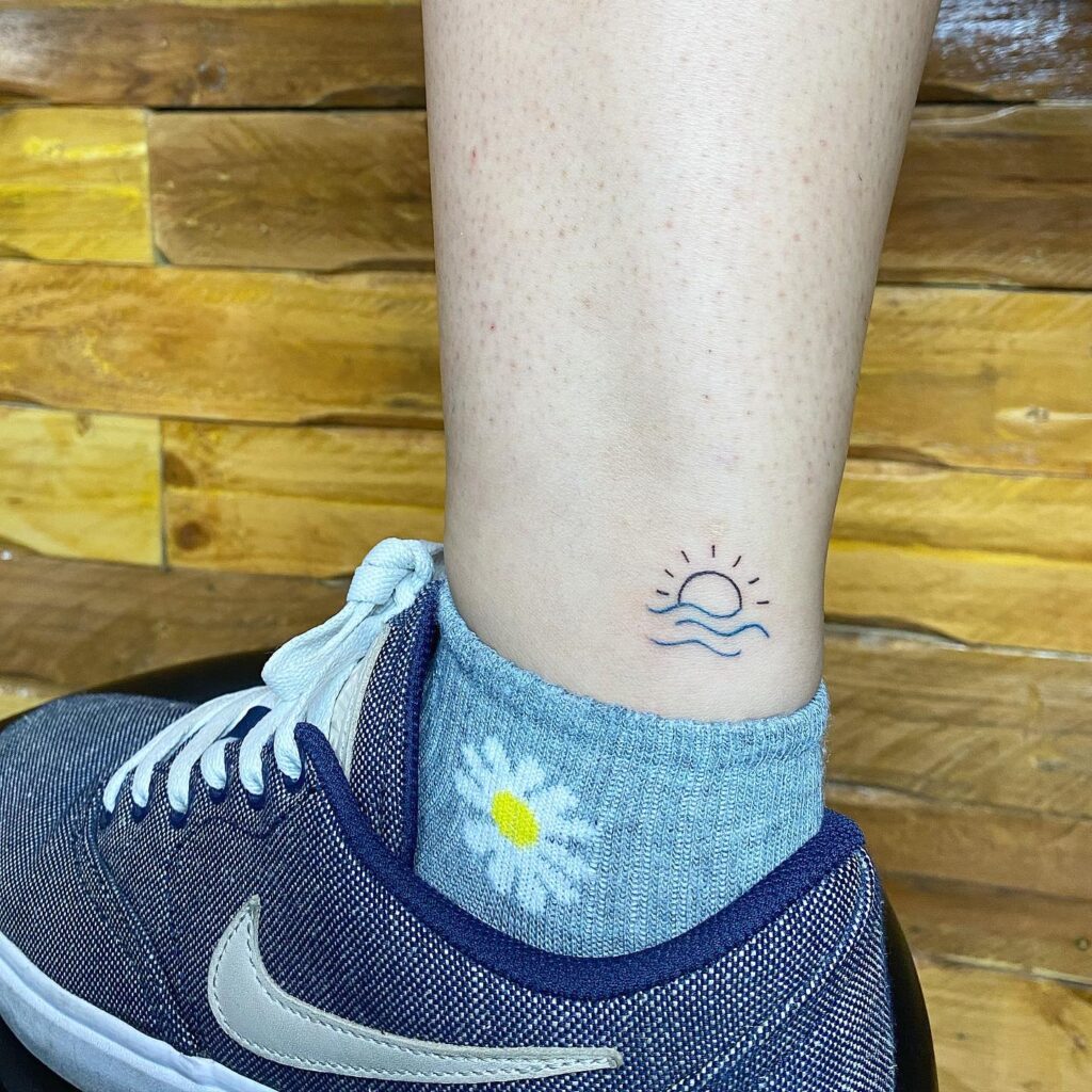 Sun and ocean ankle tattoo design for girls coastal beauty in ink