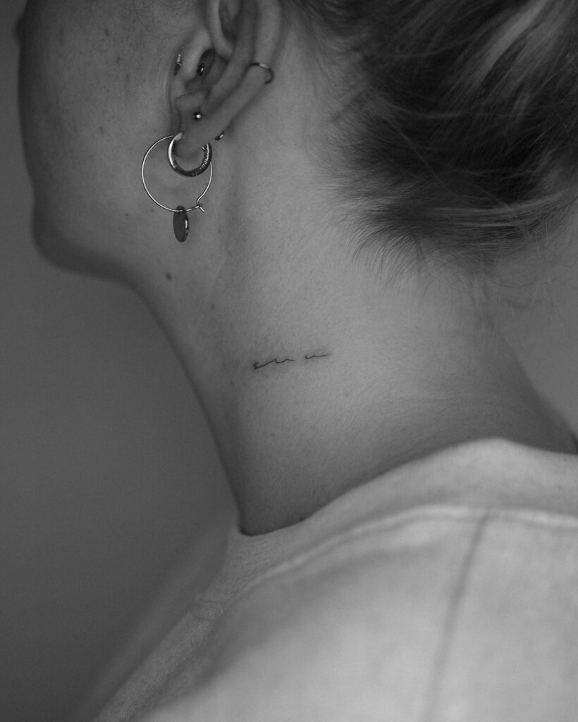'sun' handwriting tattoo on the left side of the neck, crafted in very thin lines solar elegance