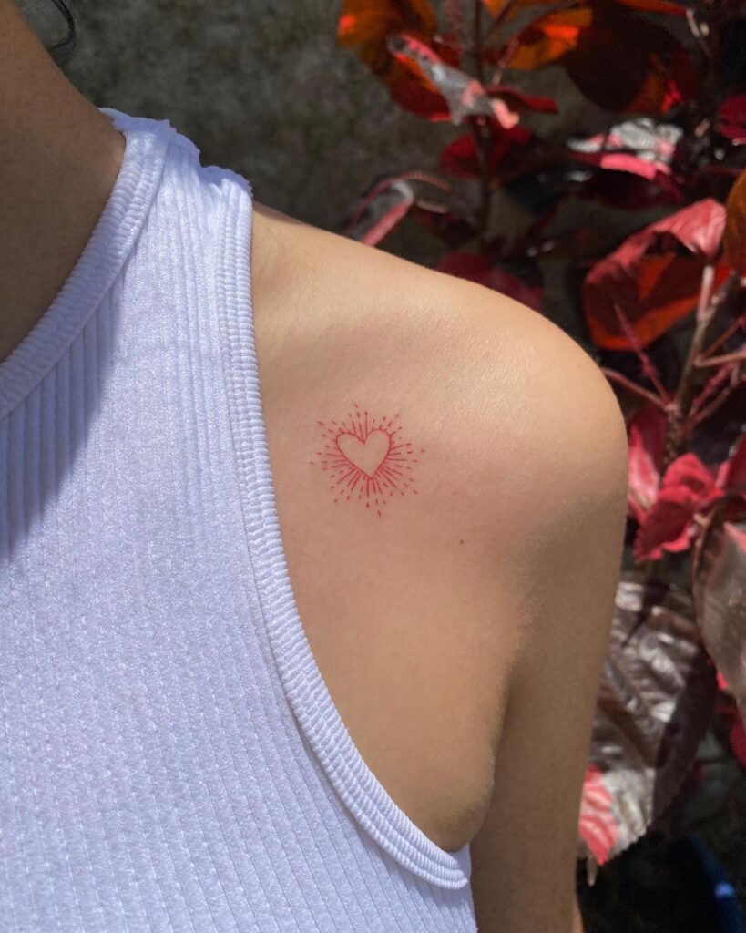 Sun-kissed collarbone red heart with sun rays tattoo