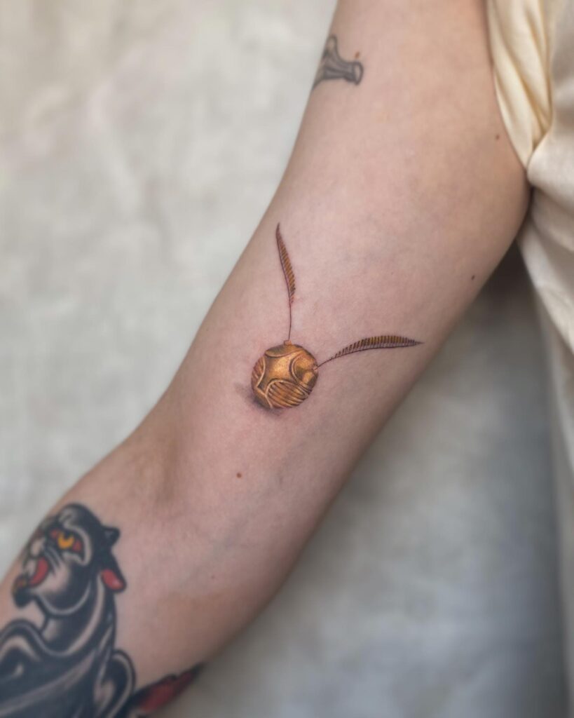 Super cool full color side arm golden snitch tattoos for girl vibrant magic