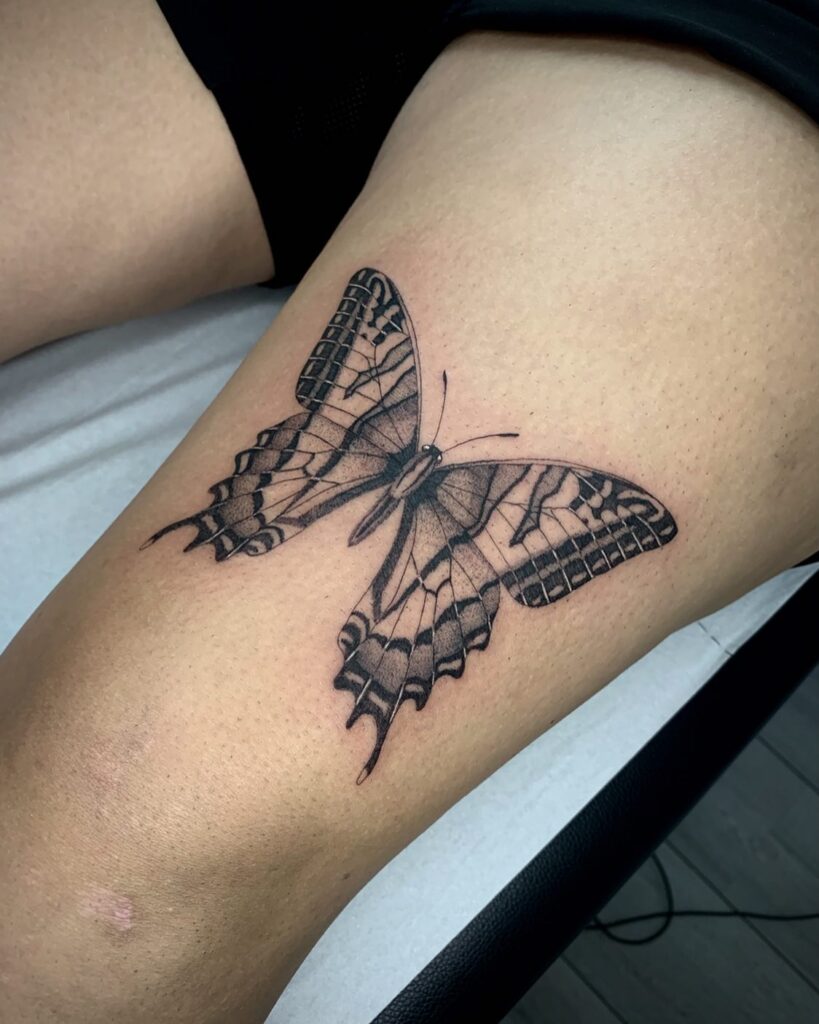 Swallowtail butterfly tattoo in black elegant thigh art