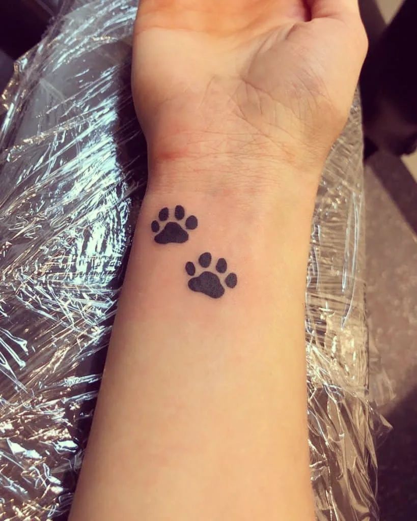 Symmetry in minimalism two black dog paw prints on the inner wrist