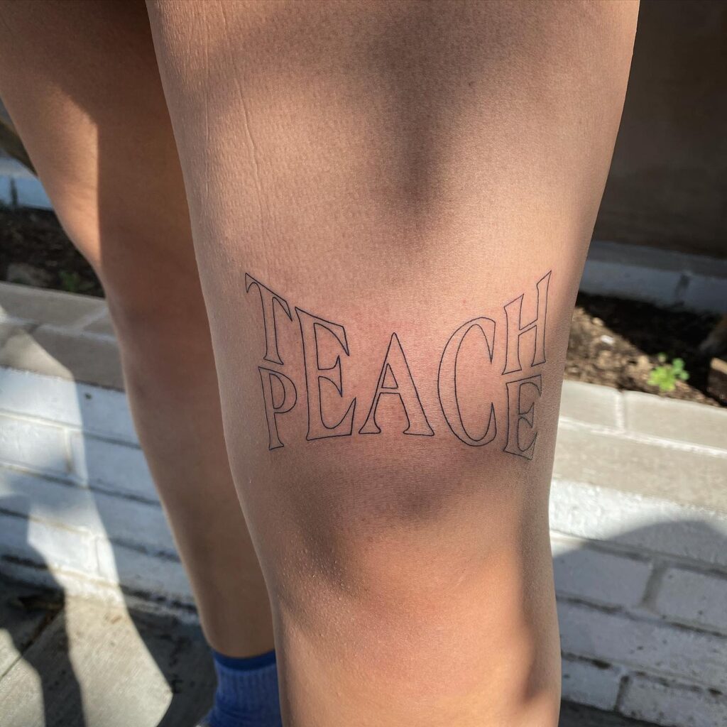 "Teach Peace" Tattoo Above the Knee: Meaningful Ink for Girls