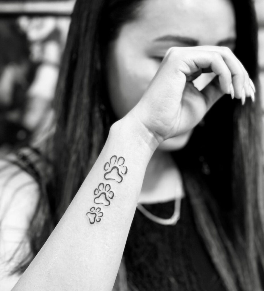 Three Dog Paws Outline Tattoo in a Subtle Row: Wrist Harmony