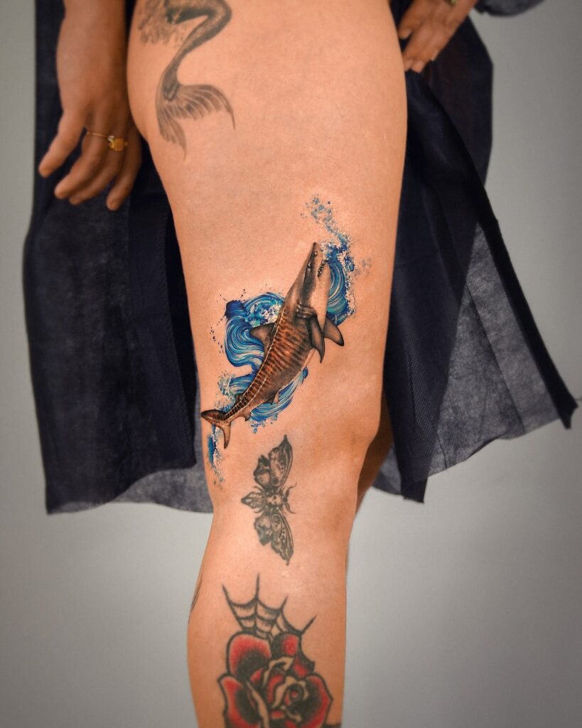 Tiger shark tattoo bursting through ocean waves with dynamic shading and intense realism