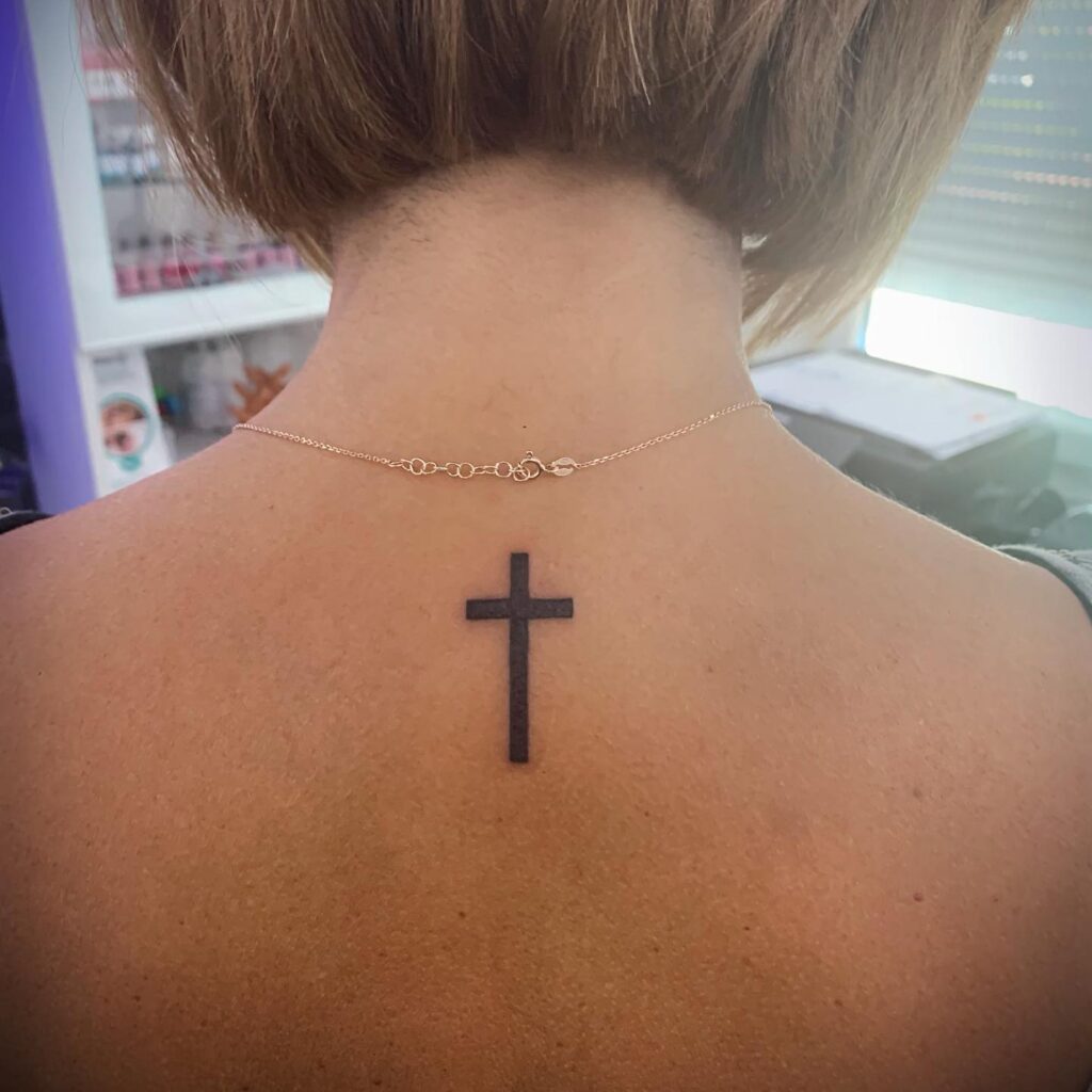 Timeless Elegance Black Ink Cross Tattoo at the Back of the Neck