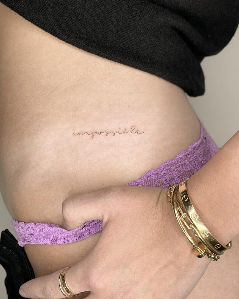 Tiny 'Impossible' Handwriting Tattoo on the Side Hip: Infinite Possibilities