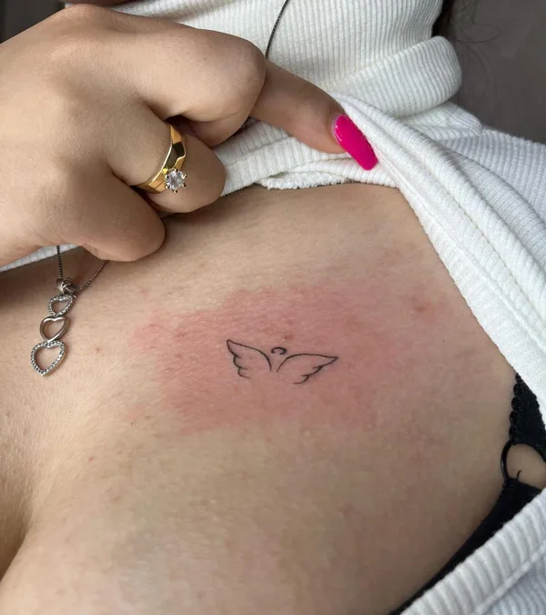 Tiny angel wings tattoo
