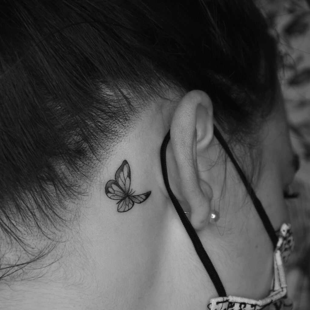 Tiny butterfly behind the ear tattoo for ladies subtle elegance