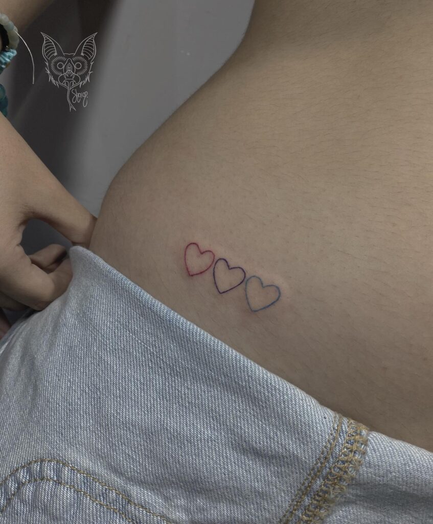 Tiny colorful heart trio outline love tattoo on the stomach