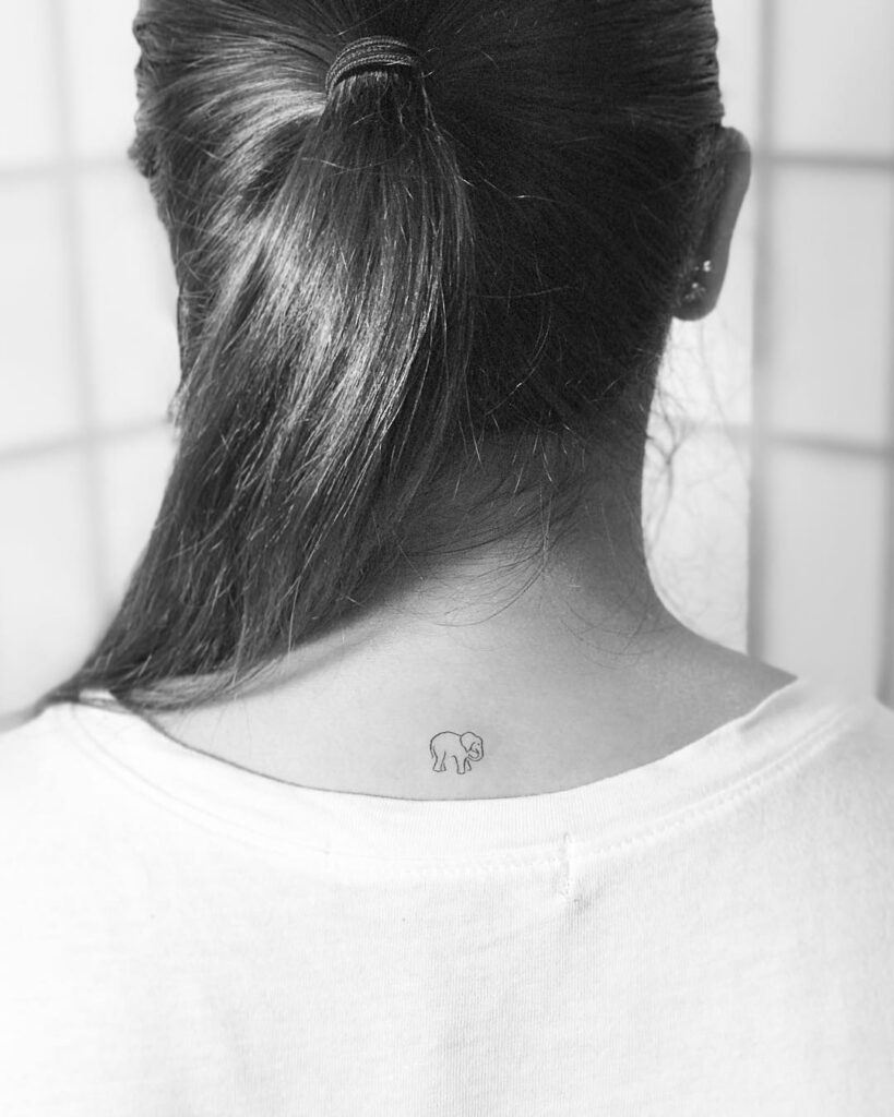 Tiny elephant outline tattoo on the back of the neck, minimalistic linework for a gentle touch subtle majesty