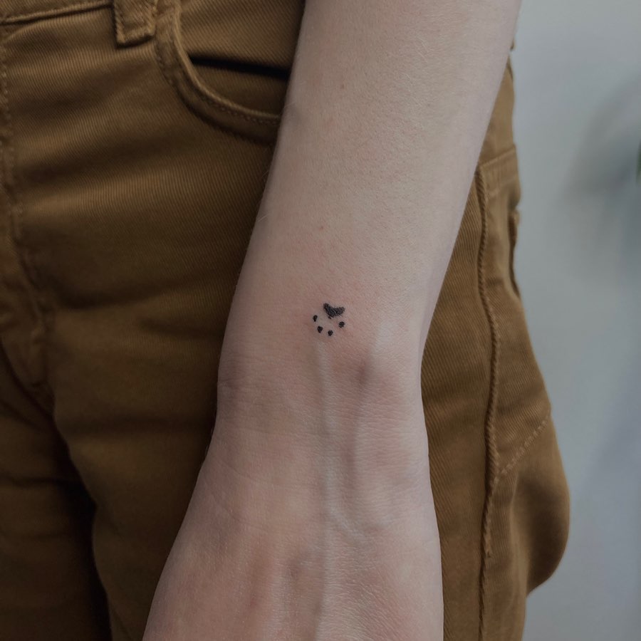 Tiny Minimalistic Paw Print Tattoo on the Outer Wrist: Subtle Wrist Whispers