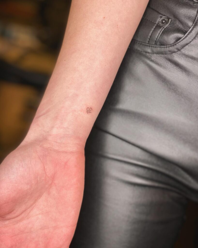 Tiny Om Symbol Tattoo on the Side of the Wrist: Wrist Harmony
