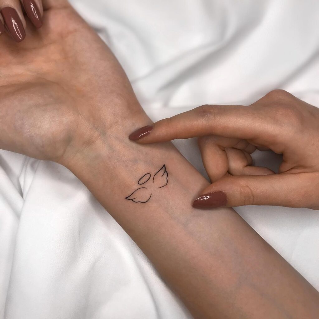 Tiny Outline Angel Wing Tattoo on the Wrist for a Cute and Simple Accent: Delicate Uplift