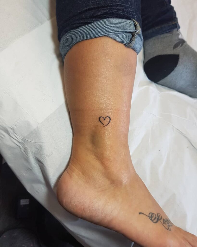 Tiny outline love heart above the ankle for women dainty and delightful