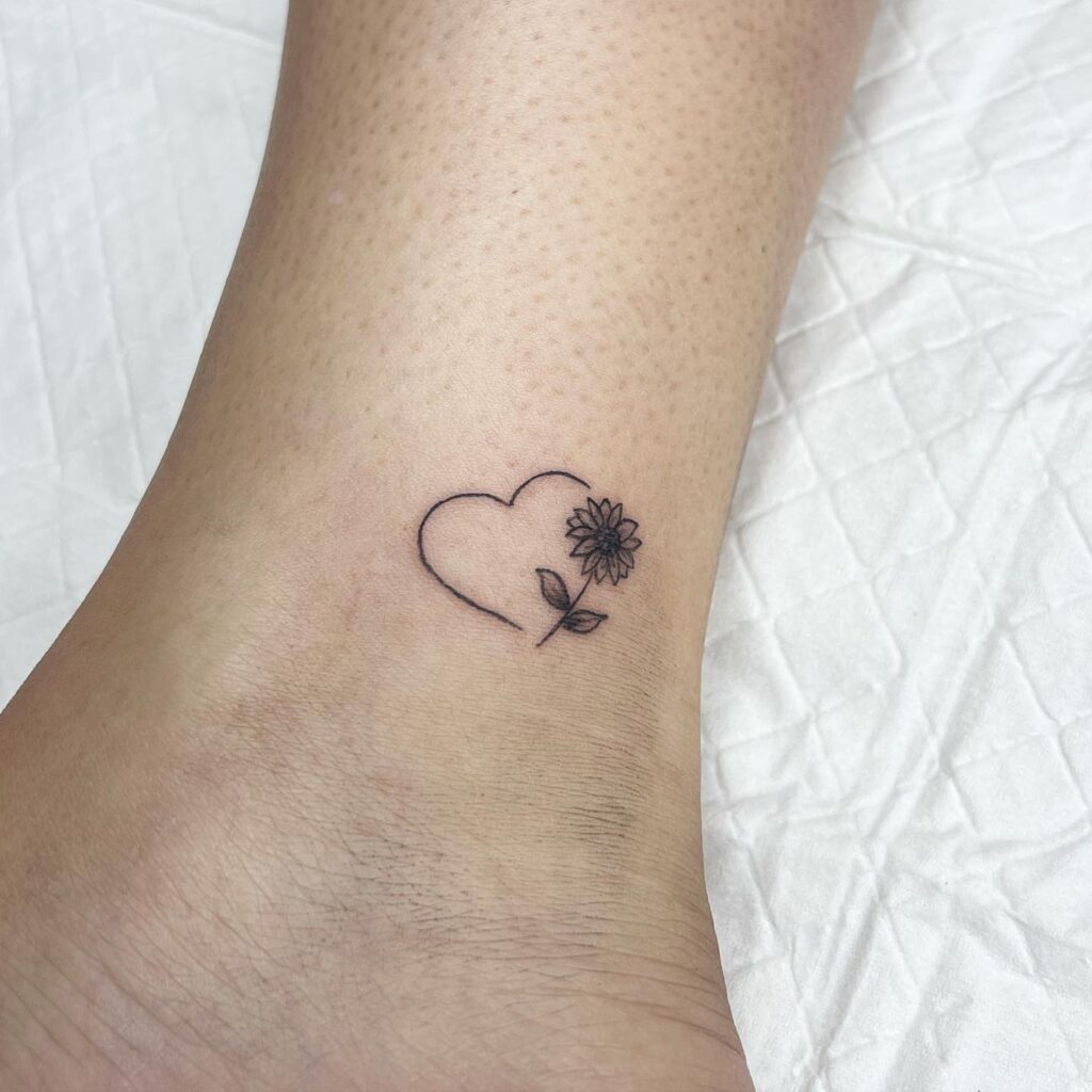 Tiny sunflower heart above the ankle tattoo