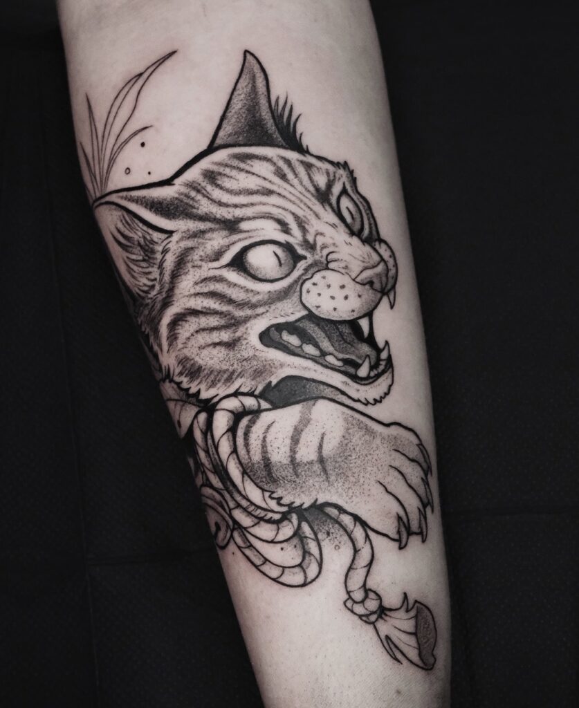Traditional fierce cat forearm tattoo with Japanese rope symbolism