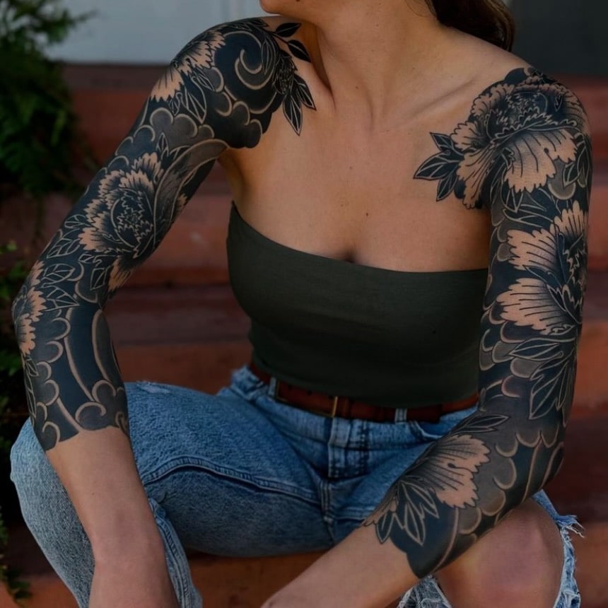 Traditional Japanese peony tattoo sleeve with deep blackwork contrast