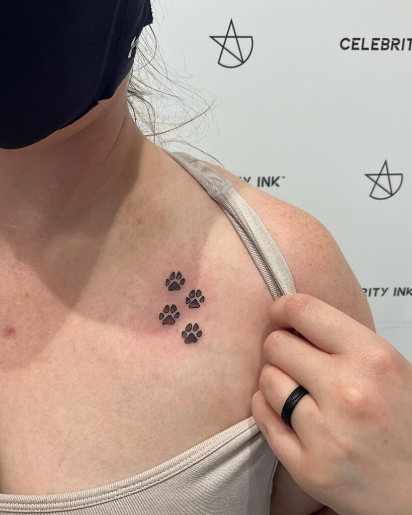 Trio of Small Dog Paw Tattoos on the Collarbone for a Minimalist Flair: Collarbone Companions