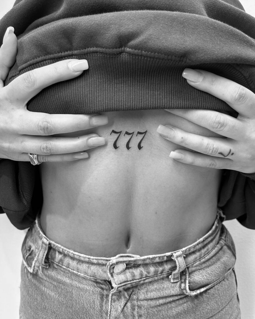 Under boob tattoo with angel number 777, infusing boldness and luck into the inked canvas lucky charms 