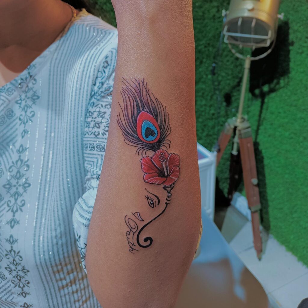Unique Hibiscus and Peacock Feather Tattoo on Forearm Natural and Symbolic
