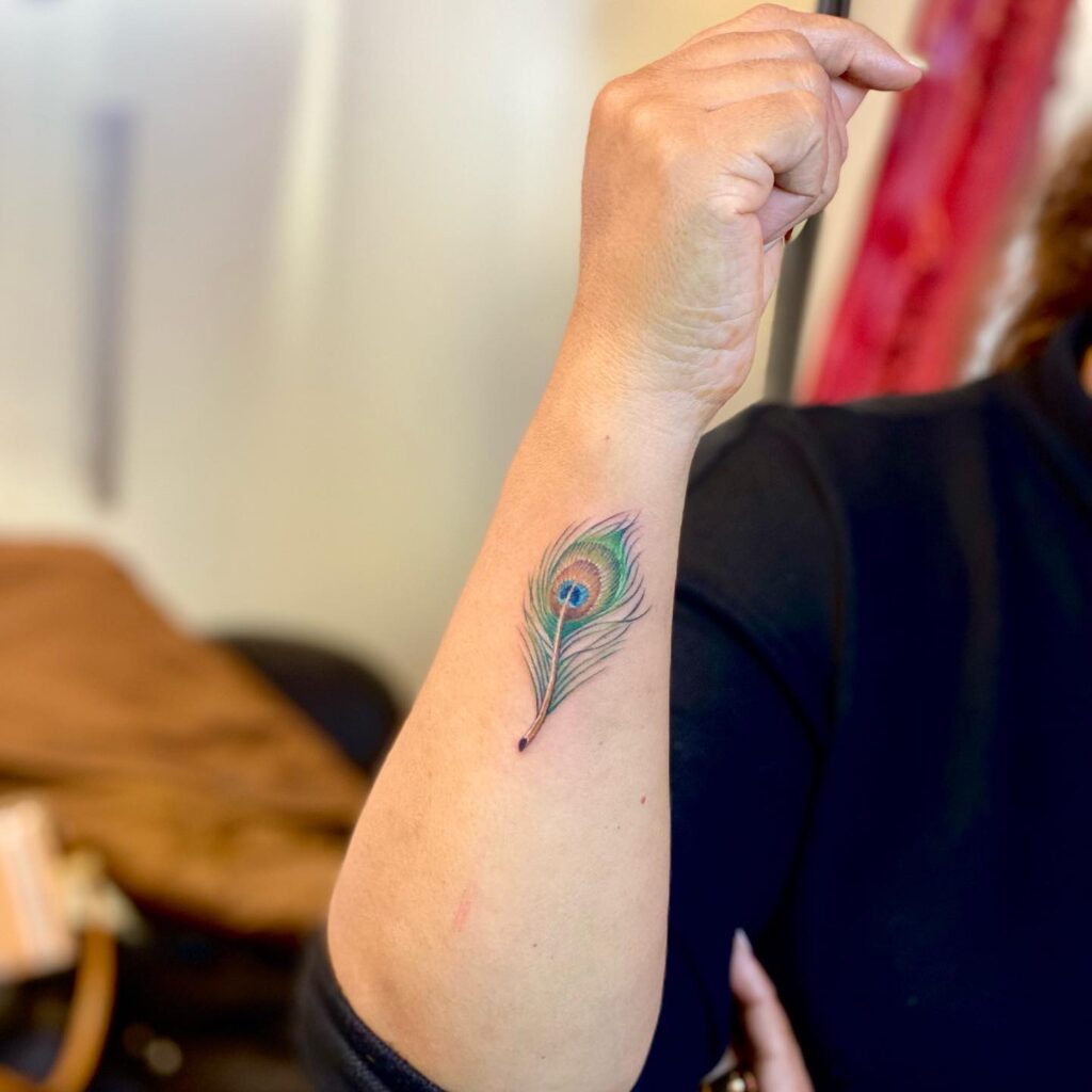 Unique Side Arm Peacock Feather Tattoo for Females : Graceful and Stylish Design