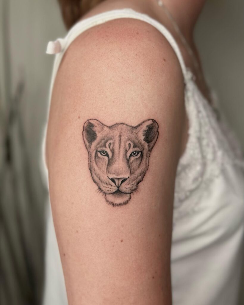 Upper arm lioness face tattoo idea for females: feminine pride